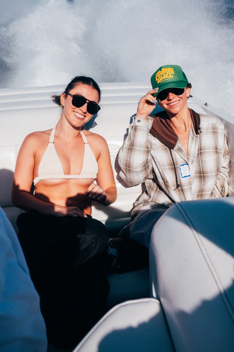 Two women smiling on a boat with Catalina hillside behind them