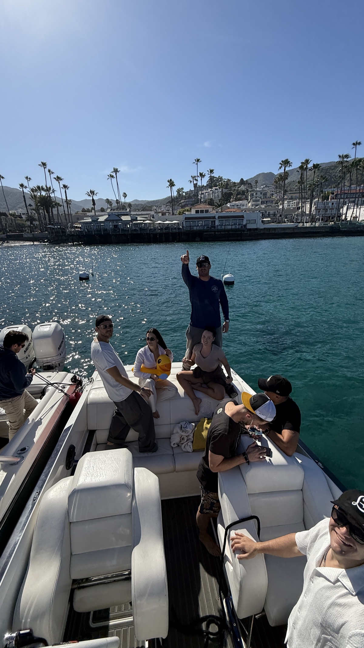 Group of friends hanging out on a boat rafted up in Avalon Harbor
